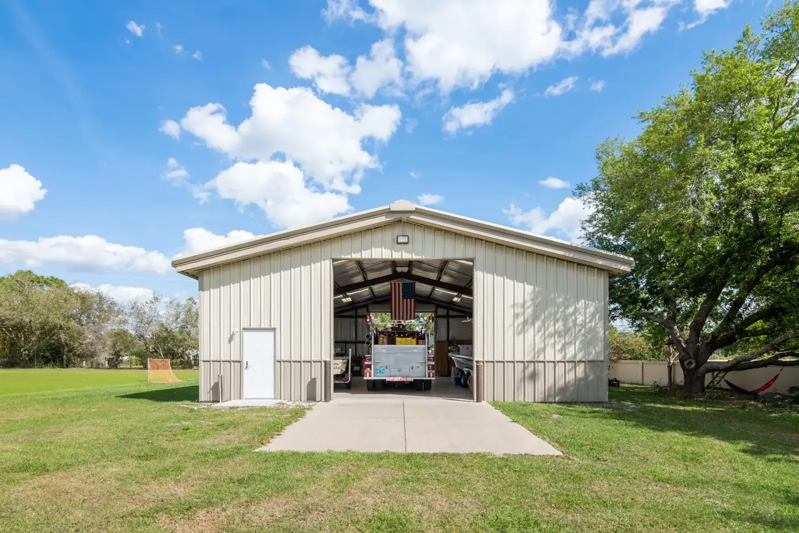 Large enclosed metal workshop garage with the roll-up door open
