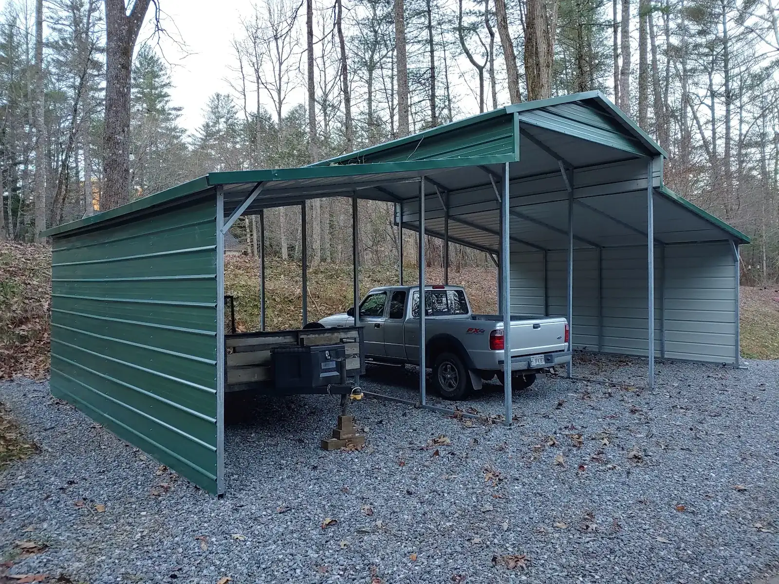 Vertical roof metal carport covering a truck and camper in Hiawassee, GA